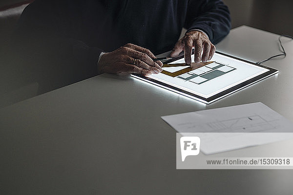 Nahaufnahme eines älteren Mannes mit Tablett mit Architekturplan