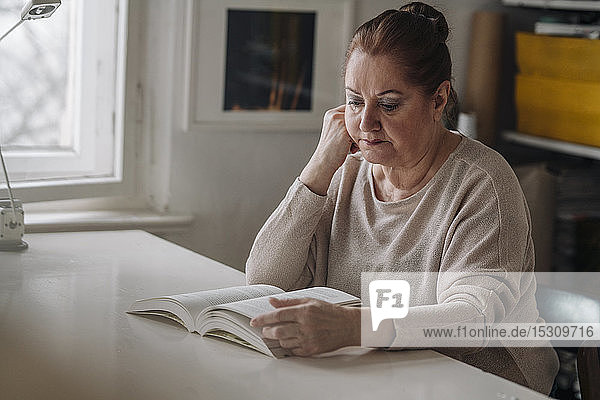 Ältere Frau liest zu Hause Buch
