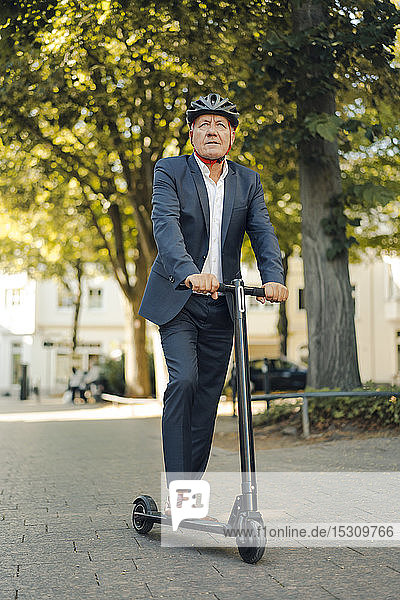 Älterer Mann fährt E-Scooter in der Stadt