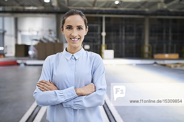 Porträt einer lächelnden Geschäftsfrau in einer Fabrik