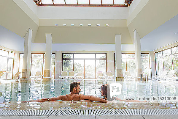 Couple relaxing in swimming pool of a spa