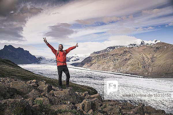 Ein erwachsener Mann steht im Skaftafell-Nationalpark und schaut auf den Vatnajokull-Gletscher  Island
