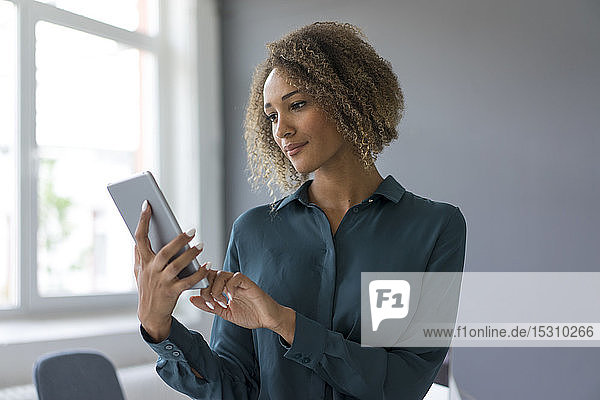 Junge Geschäftsfrau benutzt digitales Tablet im Büro