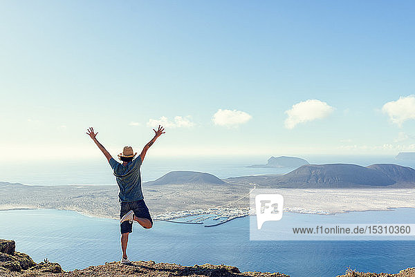 Man on viewpoint looking to La Gracioas island from Lanzarote Canary Islands Spain