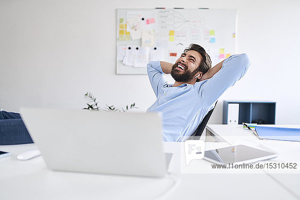 Laughing businessman sitting at a desk