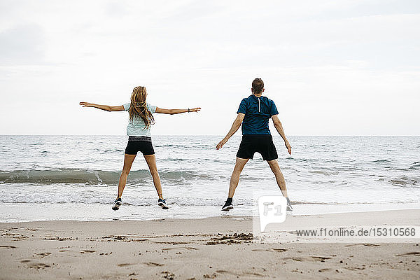 Young couple during training on the beach