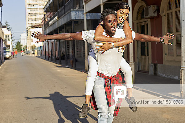 Young man carrying girlfriend piggyback in the street  Mabuto  Mozambique