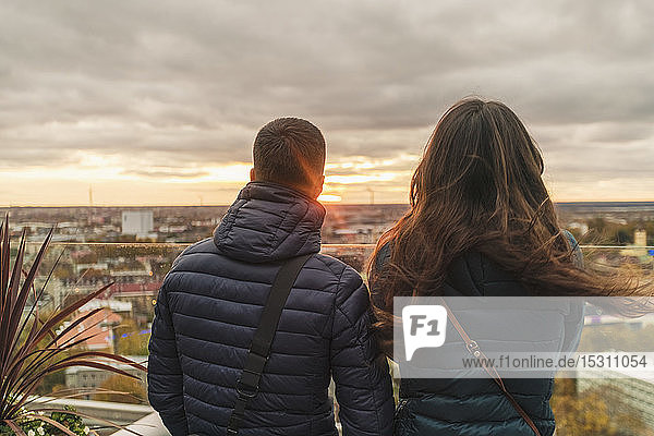 Ein Paar beobachtet den Sonnenuntergang über der Stadt von einer Aussichtsterrasse aus  Tallinn  Estland