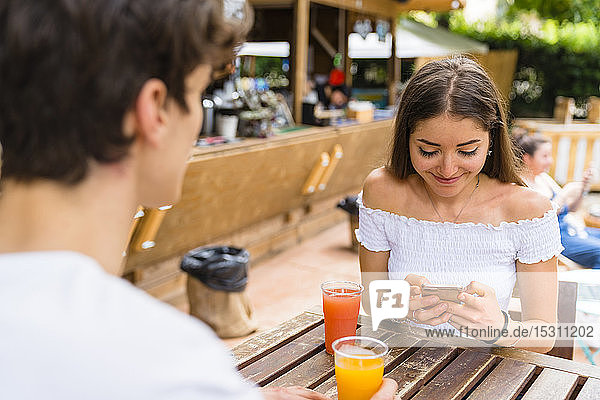 Young couple in a cafe  woman using smartphone