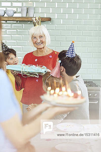 Grandchildren cleberating grandmother's birthday at home