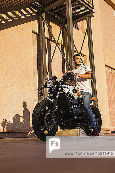 Portrait of young man sitting on his motorbike