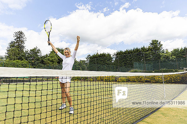 Glückliche Tennisspielerin feiert den Sieg auf Rasen