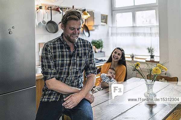 Smiling man with family in kitchen at home