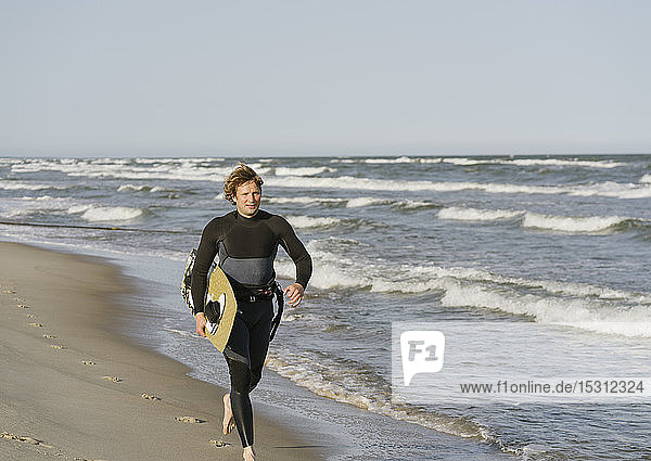 Surfer laufen am Strand