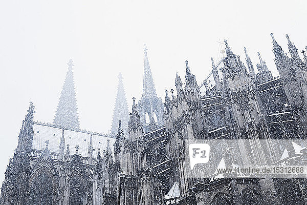 Niedrigwinkelansicht des Kölner Doms bei Schneefall in der Stadt gegen den Himmel