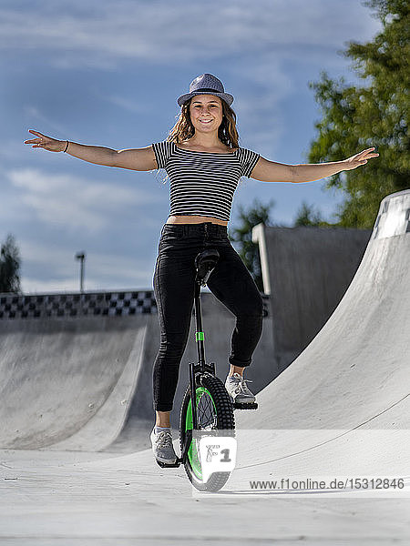 Junge Frau fährt Einrad im Skatepark