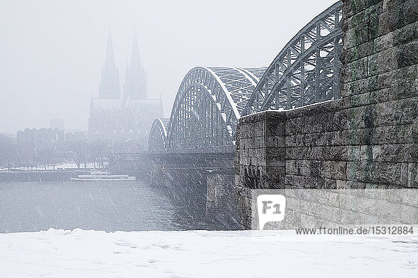 Hohenzollernbrücke über den Rhein beim Kölner Dom bei Schneefall in der Stadt gegen den Himmel