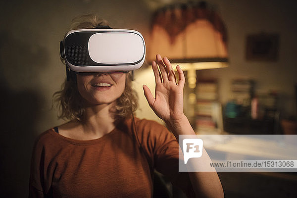 Junge Frau benutzt zu Hause eine Virtual-Reality-Brille