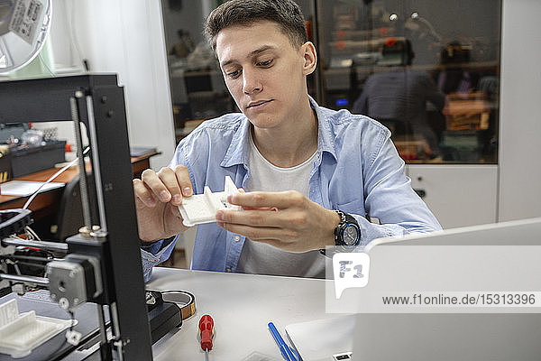 Student setting up 3D printer  using laptop