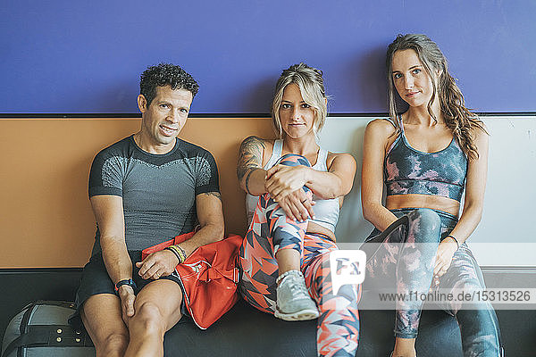 Porträt von drei Sportlern  die im Fitnessstudio eine Pause machen