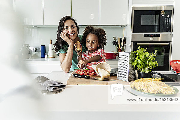 Porträt einer glücklichen Mutter und Tochter beim gemeinsamen Kochen in der Küche