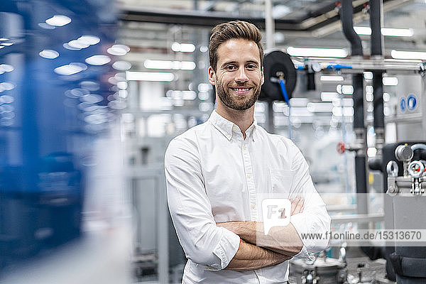 Porträt eines lächelnden Geschäftsmannes in einer modernen Fabrik