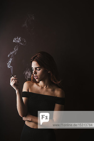 Young woman smoking marihuana at home