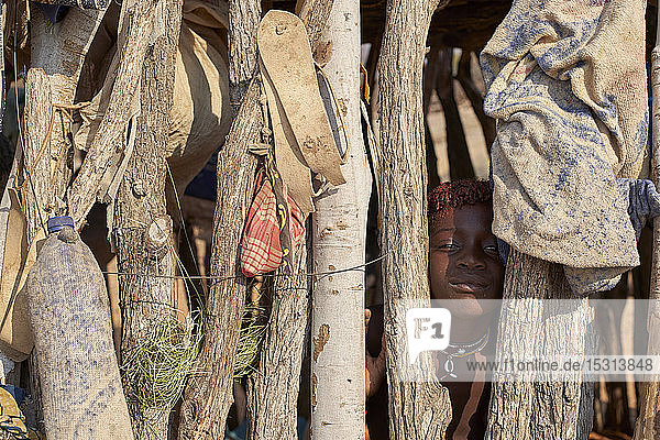 Mucubal girl hiding behind wooden fence  Tchitundo Hulo  Virei  Angola