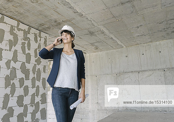 Female architect using phone at construction site