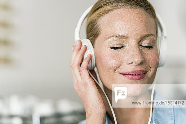 Blond woman in coffee shop with headphones  listening music