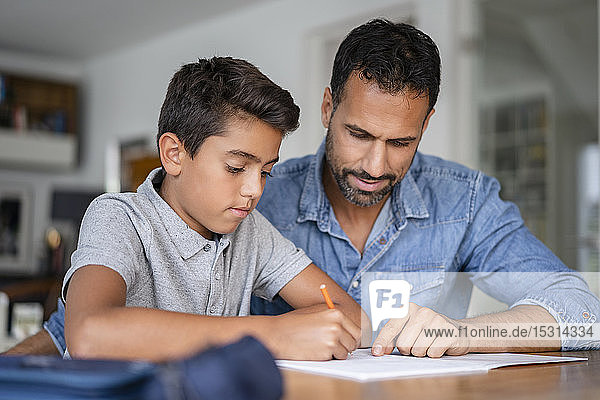Father helping son doing homework