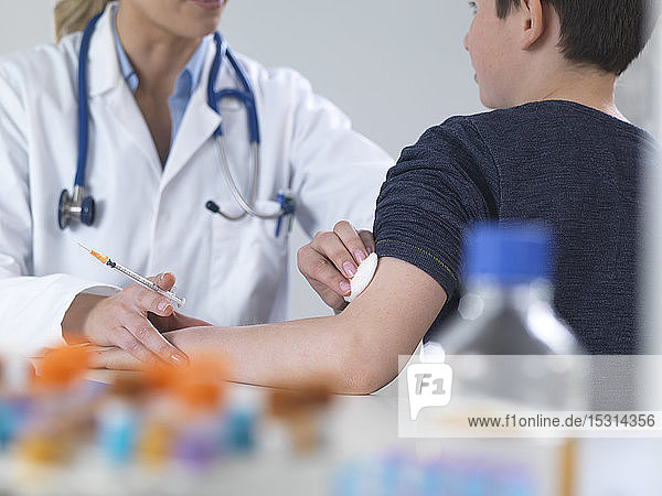 Ärztin gibt einem Jungen in der Klinik eine Routineimpfung