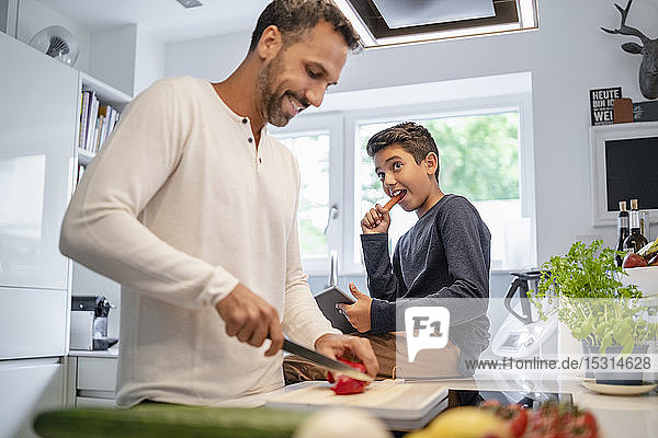 Father and son cooking in kitchen at home together