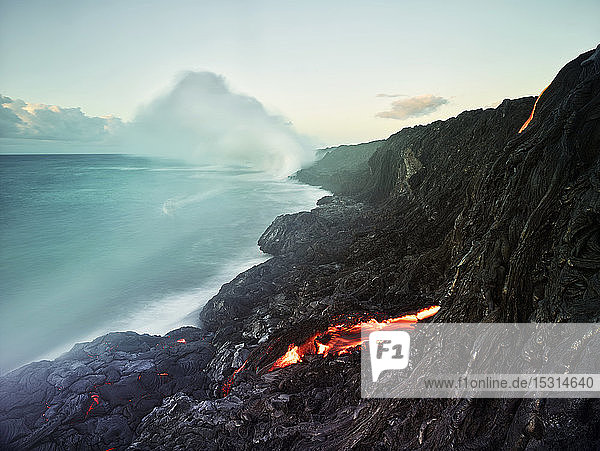 Lava flowing from Pu'u O'o' in sea at Hawaii Volcanoes National Park against sky