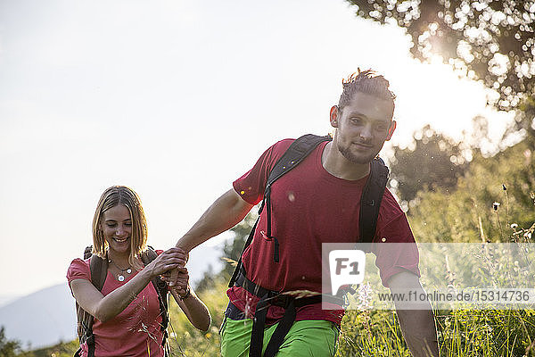 Junges Paar beim Wandern auf der Bergwiese
