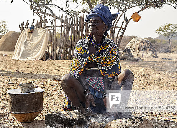 Alte mukubische Frau  die auf traditionelle Weise kocht  Tchitundo Hulo  Virei  Angola