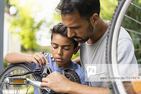 Vater und Sohn reparieren gemeinsam Fahrrad