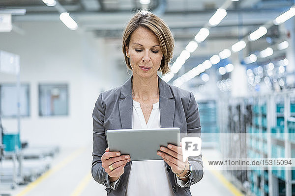 Businesswoman using tablet in a modern factory