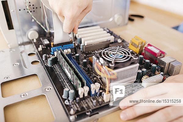 Close-up of technician repairing a desktop computer  using a screwdriver