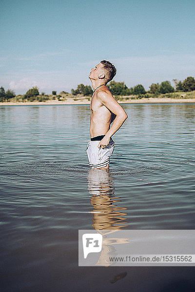 Junger Mann steht in einem See