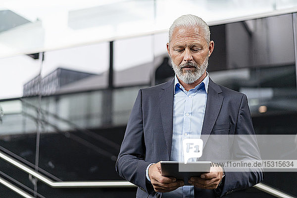 Mature businessman on a journey using tablet