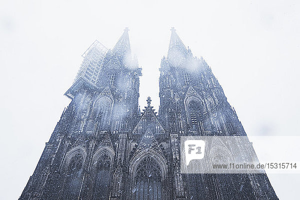 Niedrigwinkelansicht des Kölner Doms in der Stadt bei Schneefall gegen den Himmel