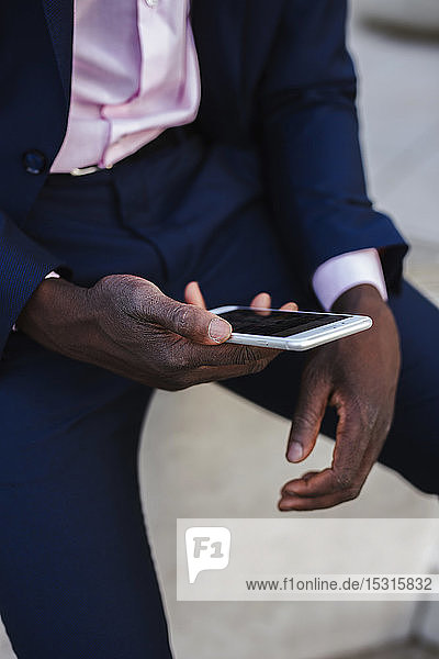 Close up of a young businessman using his smartphone