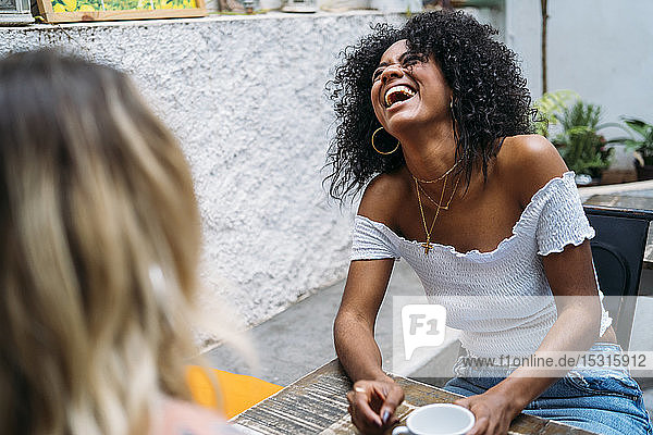 Multikulturelle Frauen lachen in einem Cafe