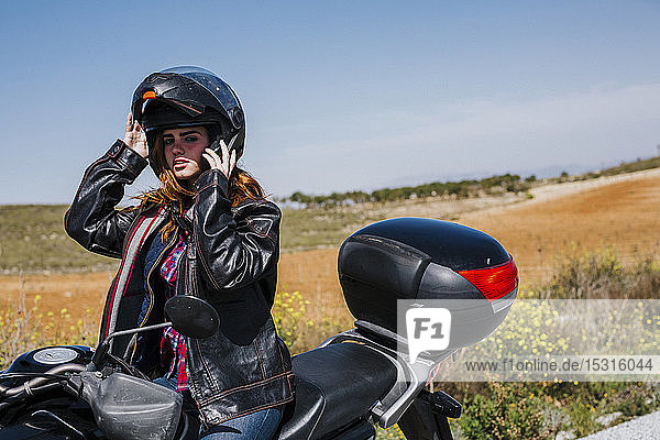 Motorradfahrer  der einen Helm aufsetzt  Andalusien  Spanien