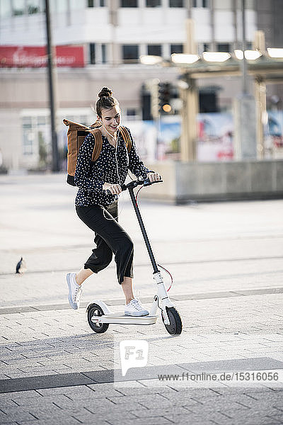 Young woman riding electric scooter in the city