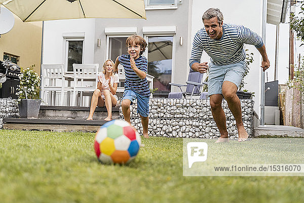 Vater und Sohn spielen im Garten Fussball