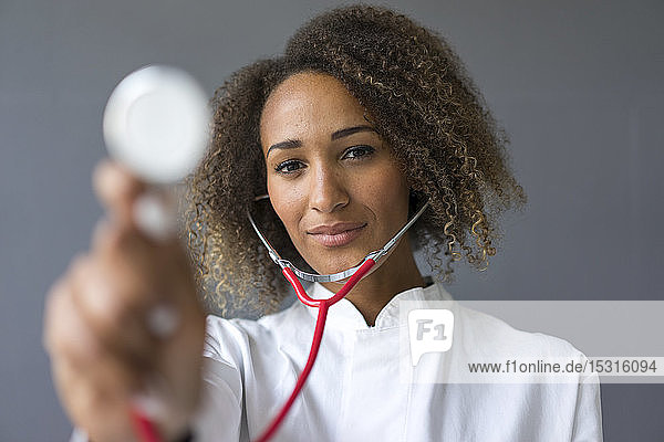 Porträt eines jungen Arztes  der das Stethoskop zur Untersuchung benutzt
