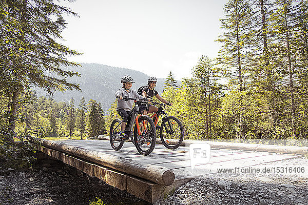 Mother and daughter riding e-mountain bikes in the mountains