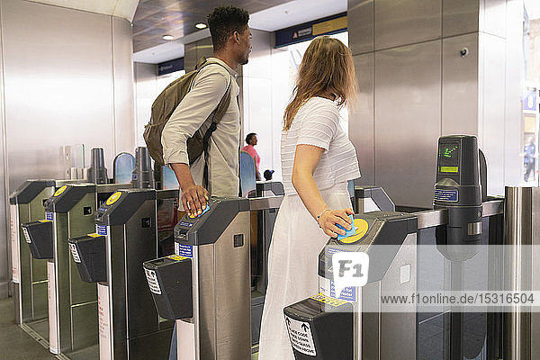 Junges Paar passiert U-Bahn-Gate mit elektronischen Tickets